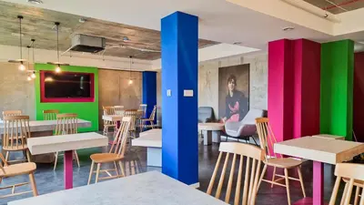 a restaurant with colorful walls and tables and chairs at Easy One Premium Art in Kraków