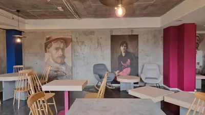 a room with tables and chairs and a painting on the wall at Easy One Premium Art in Kraków