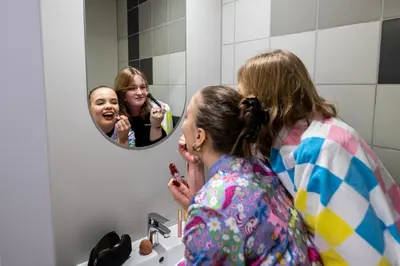 a woman brushing her teeth in front of a mirror at Easy One Premium Art in Kraków