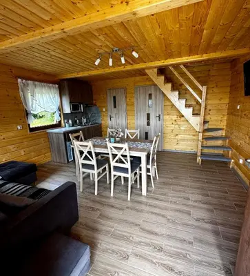 a dining room with a table and chairs in a cabin at Domek Bogdanówka in Pisarzowa