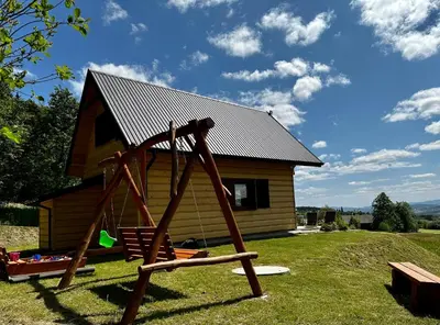 a playground in front of a log cabin at Domek Bogdanówka in Pisarzowa