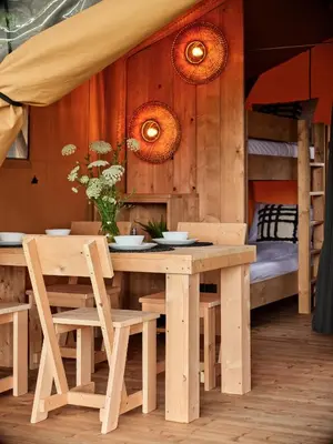 a wooden table and chairs in a room with bunk beds at Zatoria Luxury Glamping ZATOR in Zator