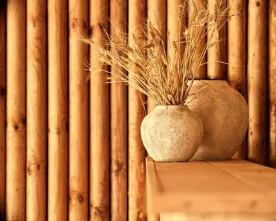 a vase sitting on a table in front of a bamboo wall at Zatoria Luxury Glamping ZATOR in Zator