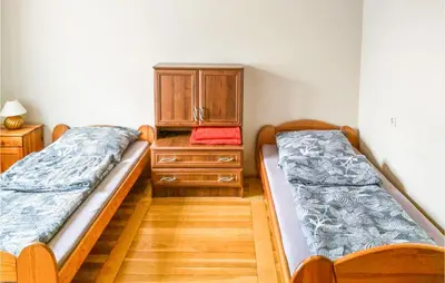two beds in a room with a dresser and a bed at Ranczo in Mogilany