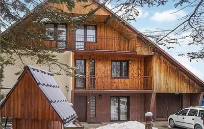 a wooden house with a car parked in front of it at Ranczo in Mogilany