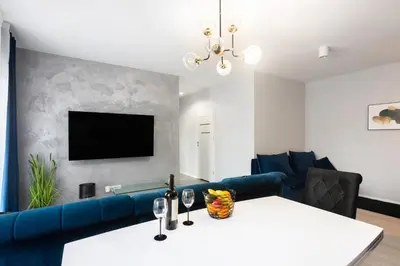 a living room with a blue couch and a tv at Margaret Apartment in Kraków
