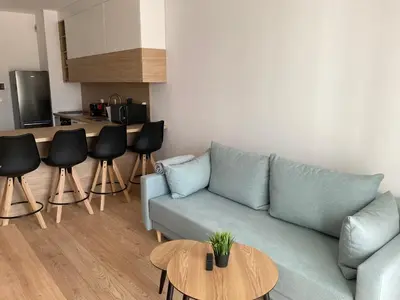 a living room with a blue couch and a table at Rakowicka Modern Apartment in Kraków