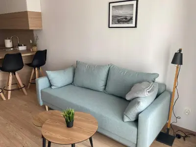 a living room with a blue couch and a table at Rakowicka Modern Apartment in Kraków