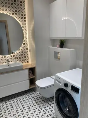 a white bathroom with a washing machine in it at Rakowicka Modern Apartment in Kraków