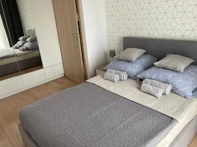 a bedroom with two twin beds and a mirror at Rakowicka Modern Apartment in Kraków