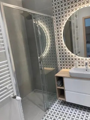 a bathroom with a shower and a sink and a mirror at Rakowicka Modern Apartment in Kraków