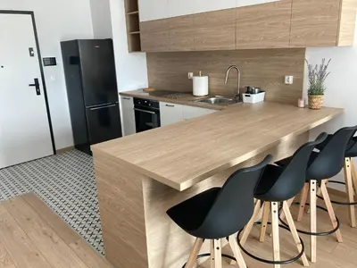 a kitchen with a wooden counter and black refrigerator at Rakowicka Modern Apartment in Kraków