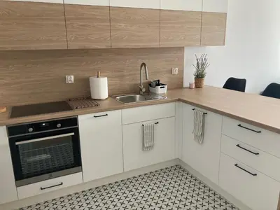a kitchen with white cabinets and a sink at Rakowicka Modern Apartment in Kraków