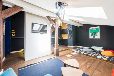 a living room with a staircase and a table and chairs at Wegierska Luxury Loft WAWELOFTS in Kraków