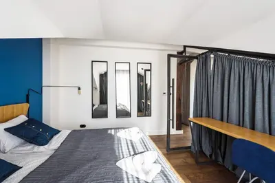 a bedroom with a bed and some mirrors at Wegierska Luxury Loft WAWELOFTS in Kraków