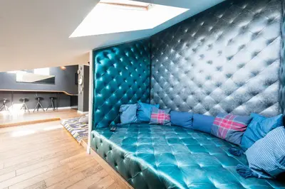 a blue couch in a living room with a wall at Wegierska Luxury Loft WAWELOFTS in Kraków