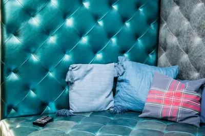 a bed with a tufted headboard and pillows at Wegierska Luxury Loft WAWELOFTS in Kraków