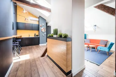 a kitchen and living room with a counter and a table at Wegierska Luxury Loft WAWELOFTS in Kraków