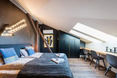 a bedroom with a large bed and a table at Wegierska Luxury Loft WAWELOFTS in Kraków