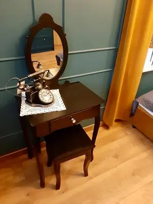 a table with a mirror and a telephone on it at Capitals Residence in Oświęcim