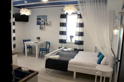 a small bedroom with a bed and a table at Capitals Residence in Oświęcim