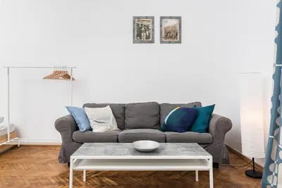 a living room with a gray couch with blue pillows at Apartments in The Jewish Quarter - LOW STANDARD - 10' Main Square - by Upstairs in Kraków