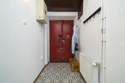 a red door in a hallway with a tiled floor at Apartments in The Jewish Quarter - LOW STANDARD - 10' Main Square - by Upstairs in Kraków