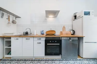 a kitchen with white cabinets and a black dishwasher at Apartments in The Jewish Quarter - LOW STANDARD - 10' Main Square - by Upstairs in Kraków