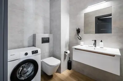 a bathroom with a washing machine and a sink at Rakowicka Old Town Luxury Apartments WAWELOFTS in Kraków
