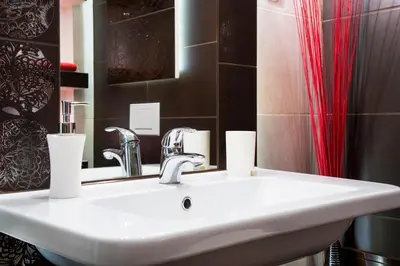 a bathroom with a sink and a red shower curtain at Neo Apartments in Kraków
