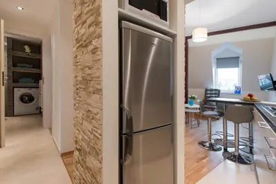 a kitchen and dining room with a stainless steel refrigerator at Neo Apartments in Kraków