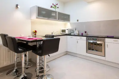 a kitchen with a table and some chairs in it at Neo Apartments in Kraków