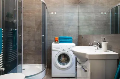 a bathroom with a washing machine and a sink at Neo Apartments in Kraków