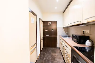 a kitchen with white cabinets and a black microwave at Salve station in Kraków