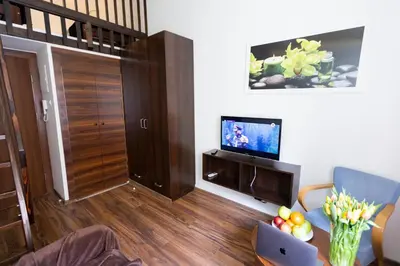 a living room with a television and a table with a laptop at Salve station in Kraków