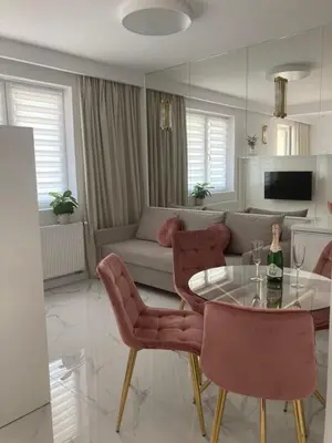 a living room with a table and chairs and a couch at Apartamenty Parkowe B18 in Oświęcim
