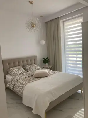 a bedroom with a large bed and a window at Apartamenty Parkowe B18 in Oświęcim