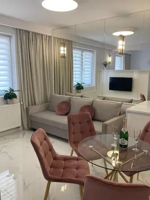 a living room with a couch and a table and chairs at Apartamenty Parkowe B18 in Oświęcim