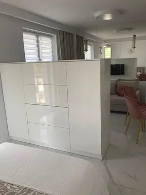 a white kitchen with a couch and a living room at Apartamenty Parkowe B18 in Oświęcim