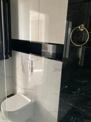 a bathroom with a toilet and a glass shower at Apartamenty Parkowe B18 in Oświęcim
