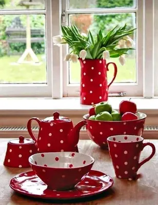 a table with red polka dot cups and a bowl of fruit at Red Bed in Jankowice