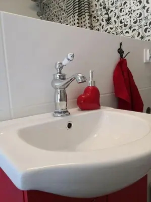 a white bathroom sink with a red heart on it at Red Bed in Jankowice