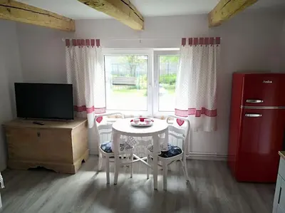 a kitchen with a table and a tv and a window at Red Bed in Jankowice