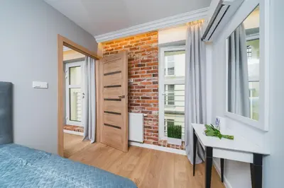 a bedroom with a brick wall and a bed and a desk at Saint Florian's Suites - Old Town Luxury Apartments - by Upstairs in Kraków