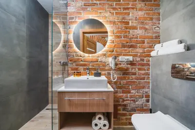 a bathroom with a sink and a brick wall at Saint Florian's Suites - Old Town Luxury Apartments - by Upstairs in Kraków