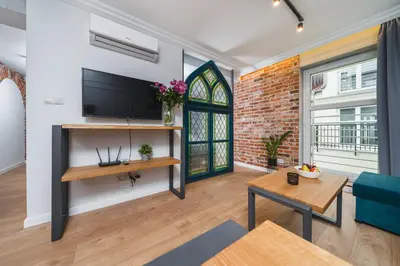 a living room with a tv and a brick wall at Saint Florian's Suites - Old Town Luxury Apartments - by Upstairs in Kraków