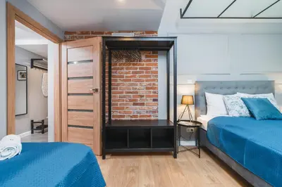 a bedroom with two beds and a brick wall at Saint Florian's Suites - Old Town Luxury Apartments - by Upstairs in Kraków