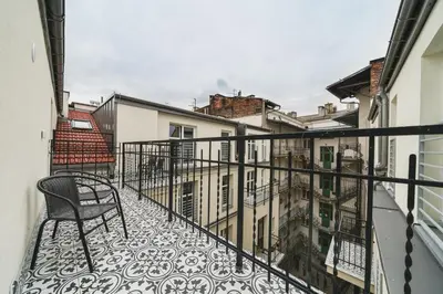 a balcony with a chair and some buildings at Saint Florian's Suites - Old Town Luxury Apartments - by Upstairs in Kraków