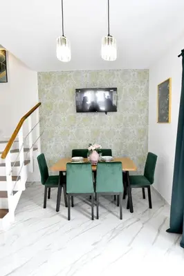 a dining room with a table and green chairs at Domki na Krótkiej in Spytkowice
