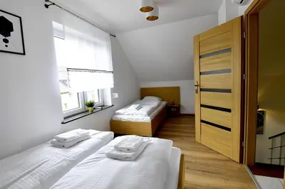 a bedroom with two beds and a wooden door at Domki na Krótkiej in Spytkowice